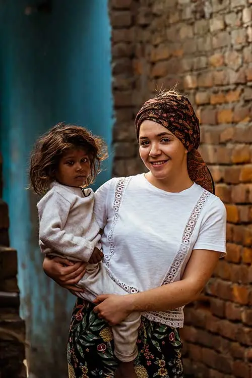 olivier.darock.photography-enfantsdeshanti_1734 bénévole tenant un enfant lors d’une mission solidaire en Inde